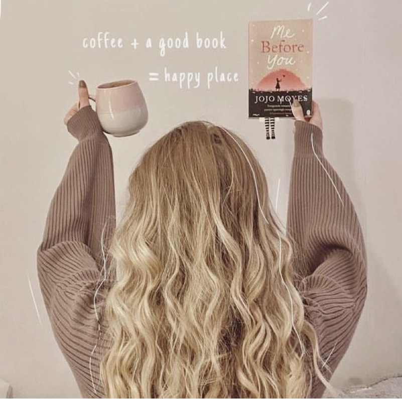 Mulher com um livro e uma caneca de café
